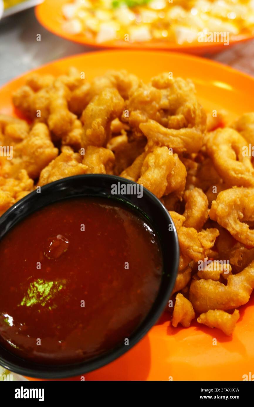 Knusprige gebratene Tintenfischringe, gebratenes Meeresfrüchtegericht mit roter Chili-Dip-Sauce Stockfoto