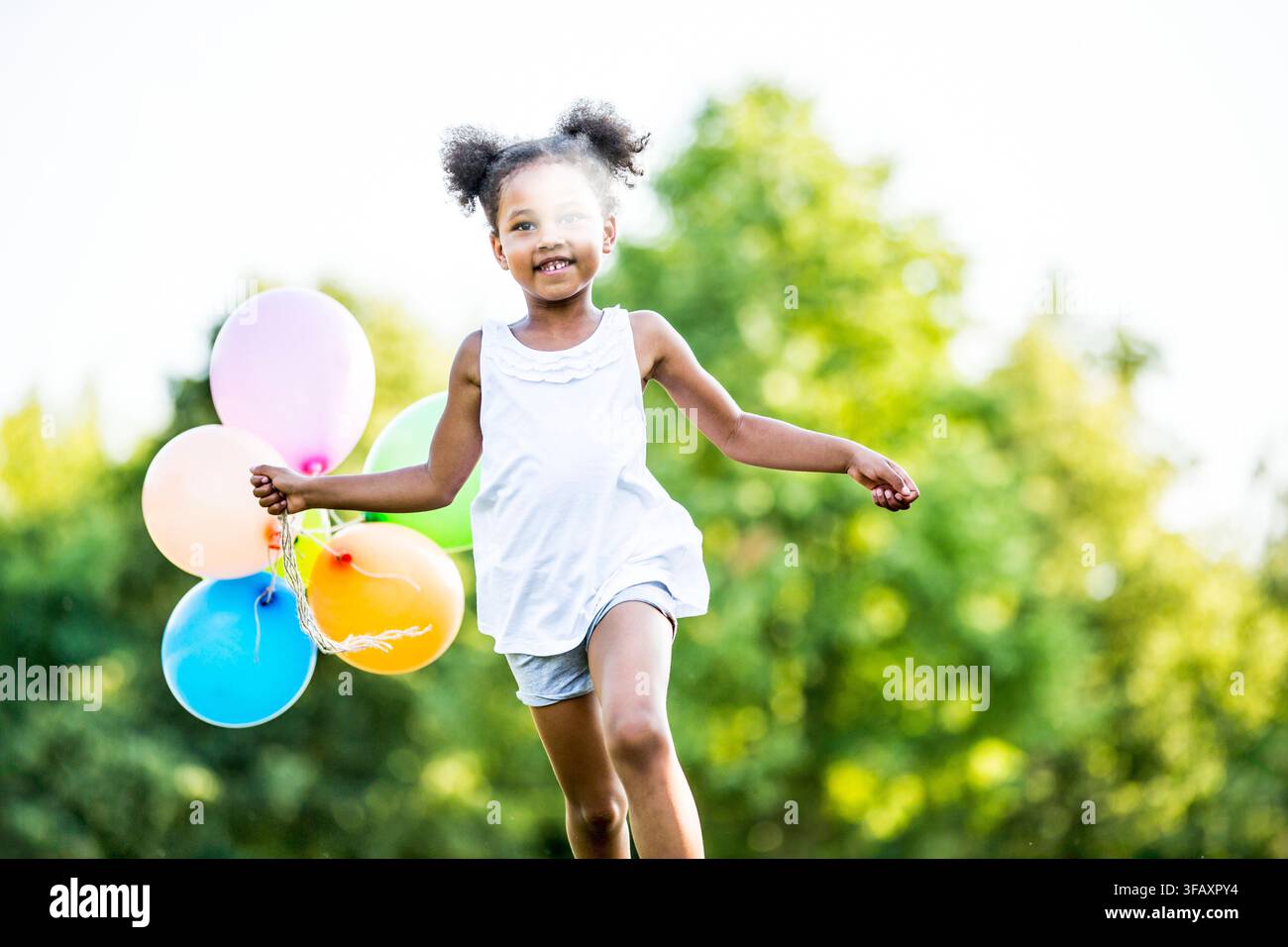 Mädchen mit Luftballons laufen. Stockfoto