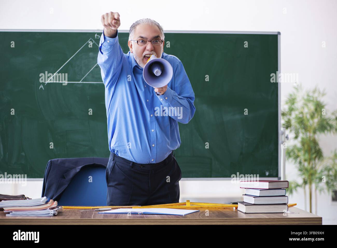 Wütender männlicher Mathematiklehrer mit Megafon Stockfoto