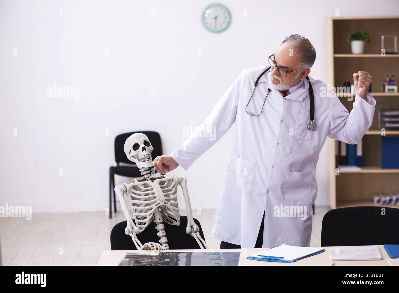 Älterer Arzt und skelettaler Patient im Krankenhaus Stockfoto