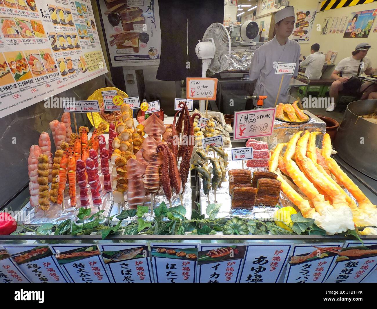 Kuromon-Markt in Osaka, Japan, Asien. Japanischer Familienbetrieb, der traditionelles Straßenessen verkauft Stockfoto
