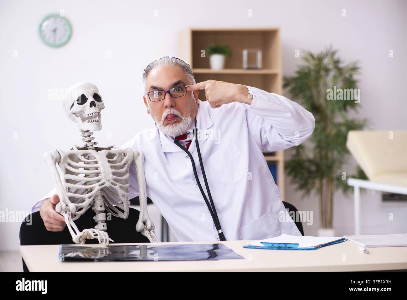 Älterer Arzt und skelettaler Patient im Krankenhaus Stockfoto