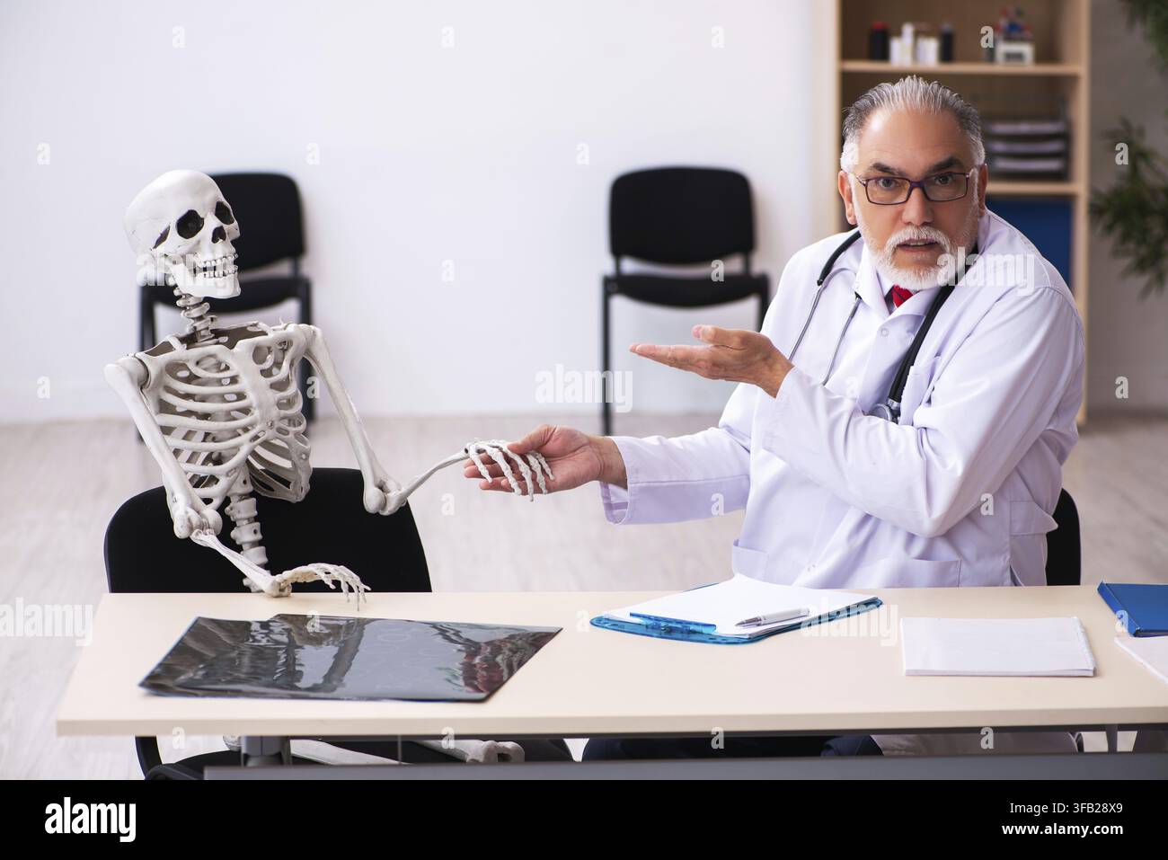 Älterer Arzt und skelettaler Patient im Krankenhaus Stockfoto