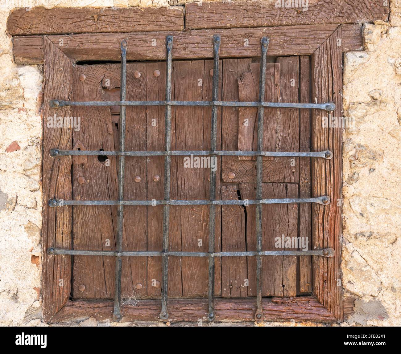 Altes Holzfenster mit schmiedeeisernen Gittern, traditionelle Architektur im Dorf Candelario, Spanien Stockfoto