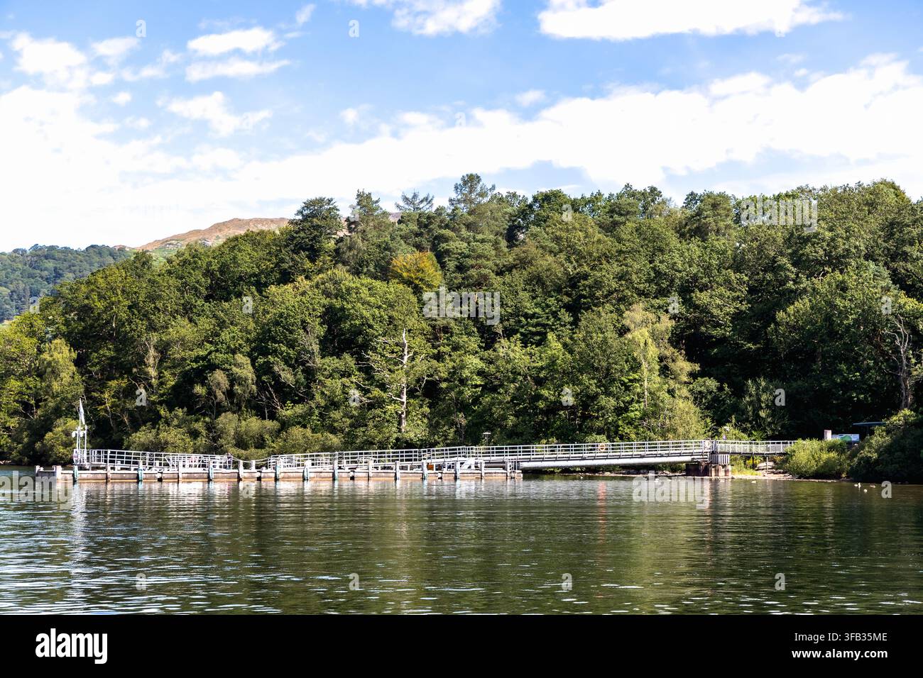 Steg und Anlegestelle am Seeufer, umgeben von dichtem Wald entlang des Lake Windermere im Lake District, Cumbria, England Stockfoto
