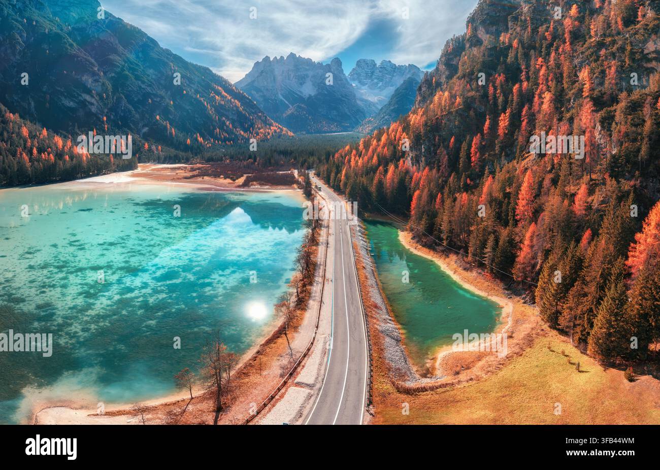 Luftbilddrohnenaufnahme einer Straße entlang eines türkisfarbenen Algensees im Herbst Stockfoto