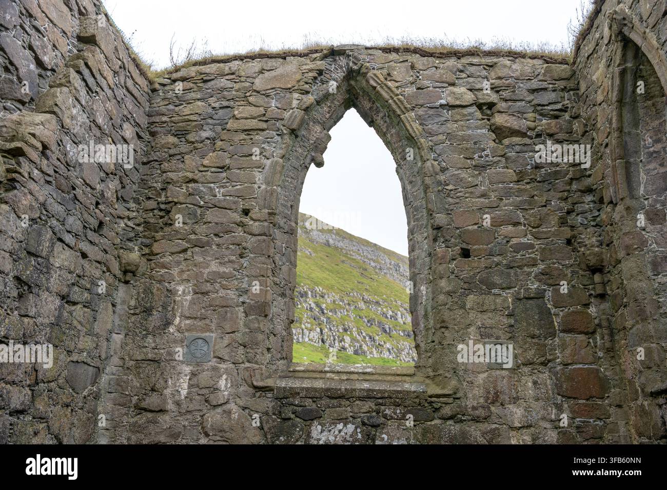 Fenster der Ruine der Saksun-Kirche, das die Landschaft der Färöer-Inseln einrahmt Stockfoto