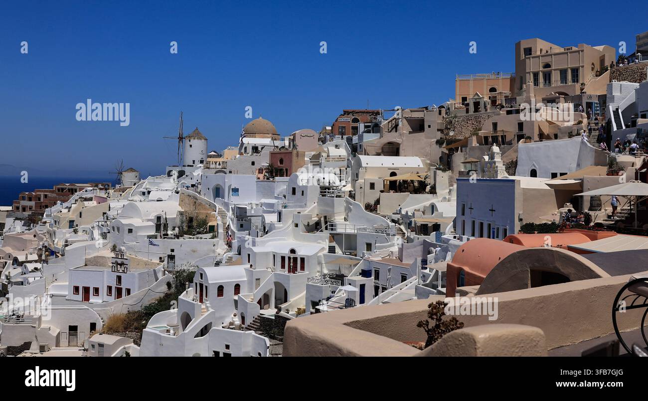 Ansicht von weiß getünchten Häusern und traditionellen Windmühlen, Oia, Santorin, Griechenland Stockfoto