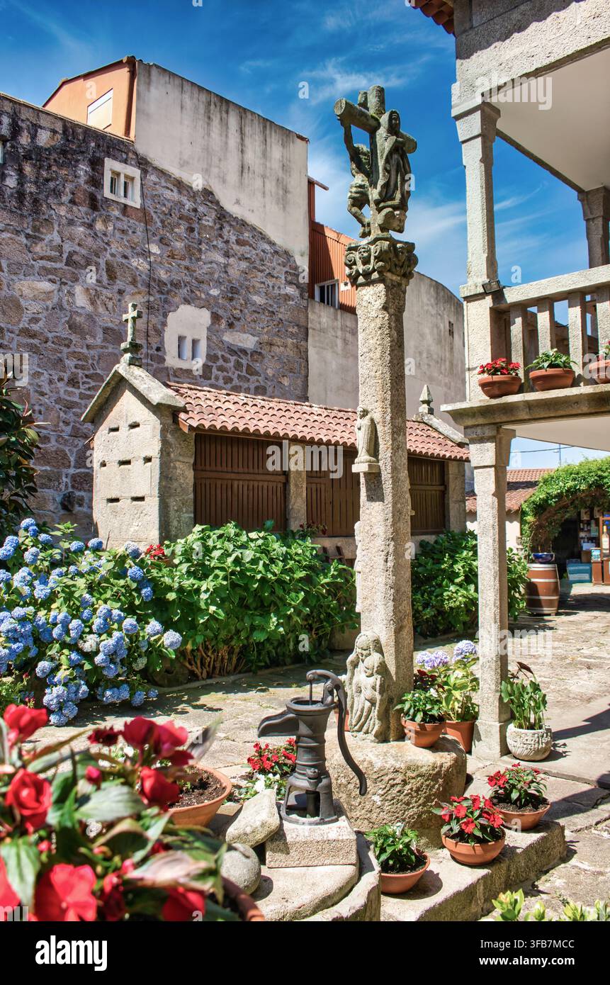 Steinkreuz und traditioneller galicischer Hórreo im alten Viertel von Cambados, Spanien Stockfoto