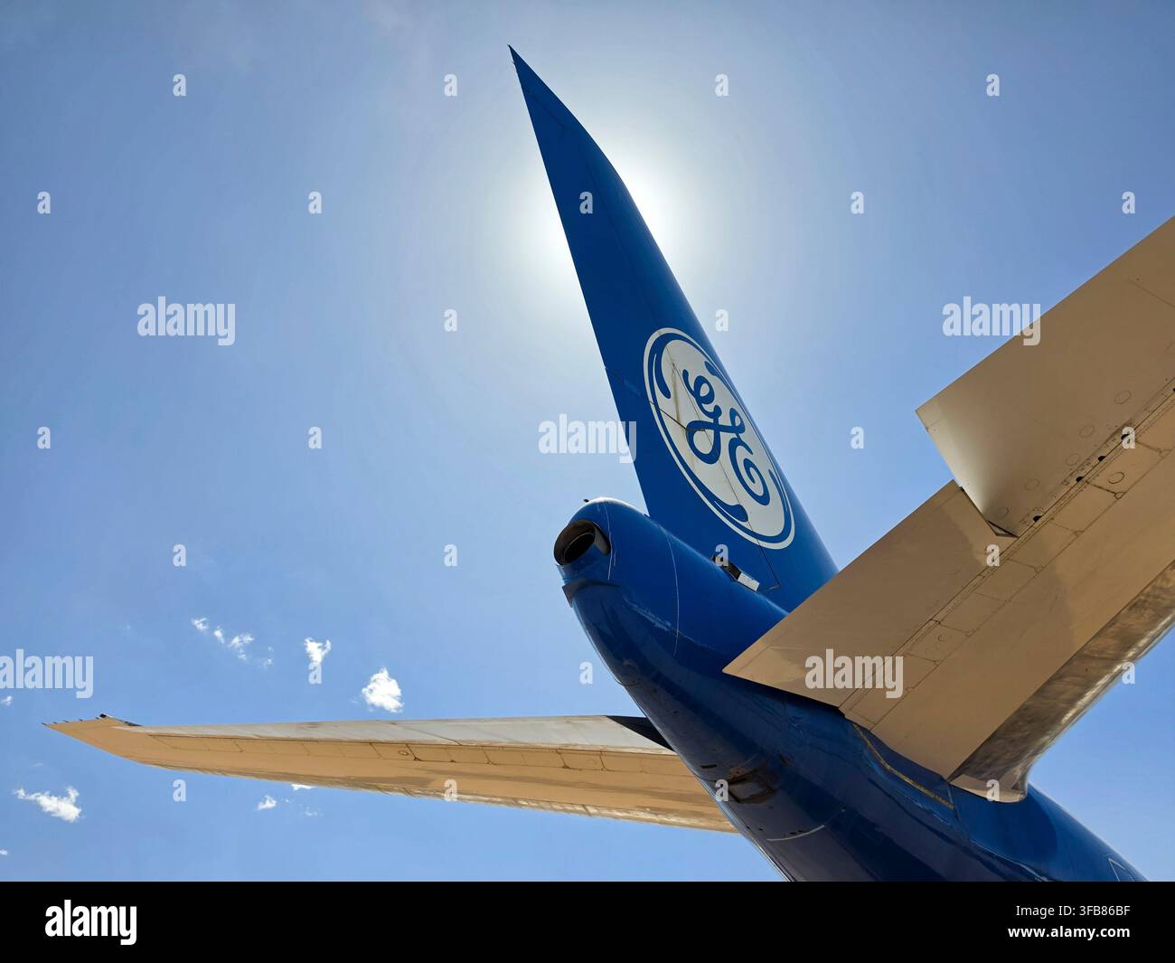 Blaues Heckflügel mit GE General Electric-Logo vor heller Sonne; GE-Flugzeug Stockfoto