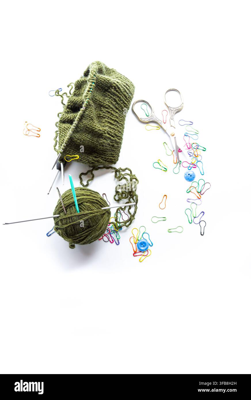 Handgefertigtes Strickprojekt mit Wollgarn und Strickwerkzeugen. Stockfoto