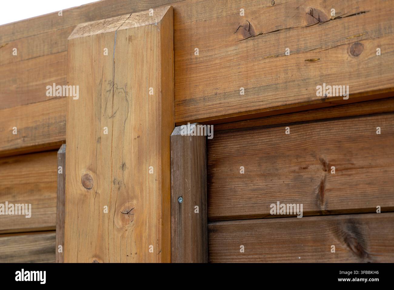 Detaillierte Textur einer gealterten Holzkonstruktion, die natürliche Holzmaserungen, Astknoten und verwitterte Oberflächen in einer rustikalen Außeneinrichtung zeigt Stockfoto