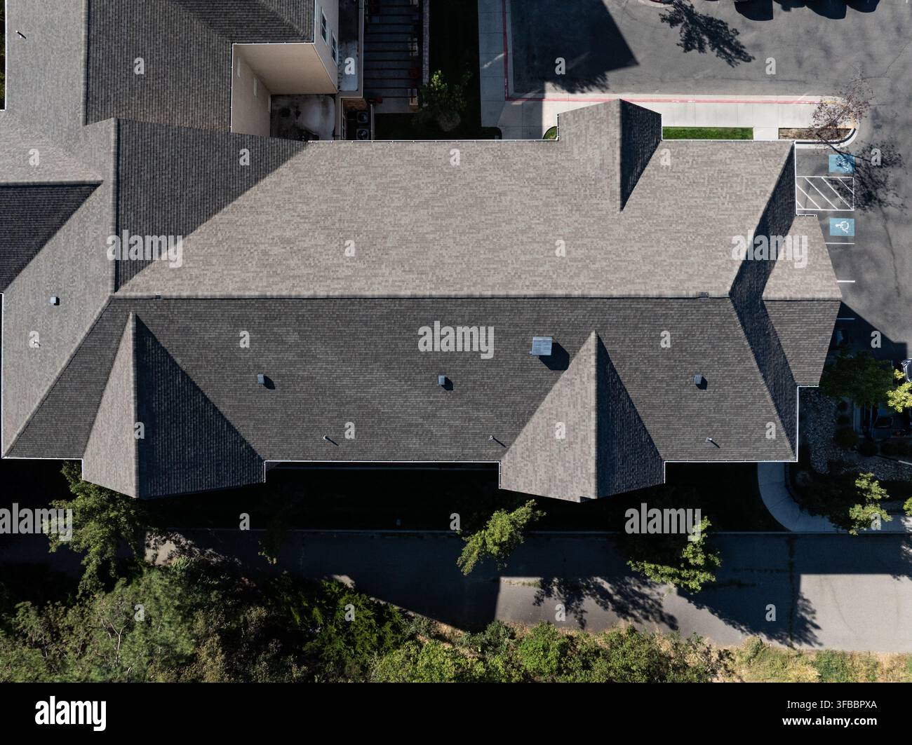 Top-Down-Foto eines Wohnhauses mit eckigem Dachdesign und gestaltetem Garten Stockfoto