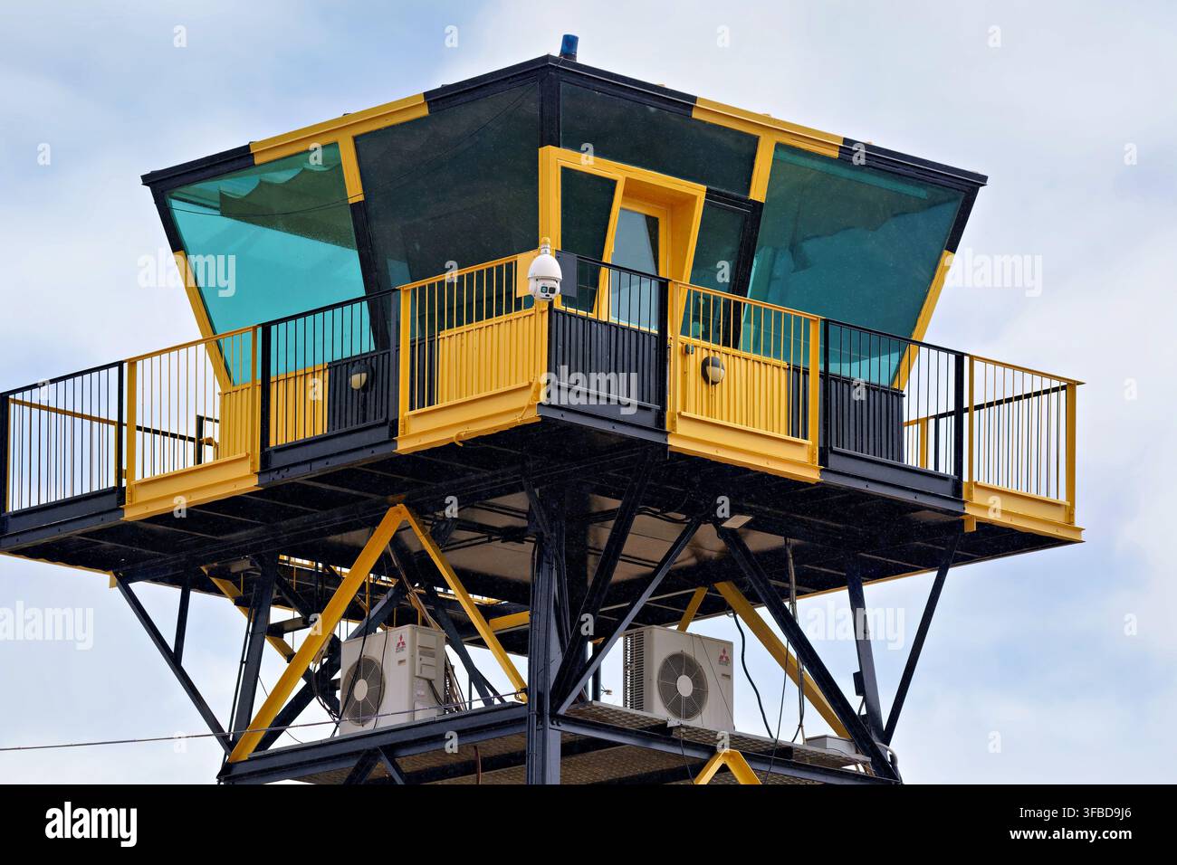 Erhöhter Aussichtsturm mit gelben und schwarzen Geländern vor bewölktem Himmel Stockfoto