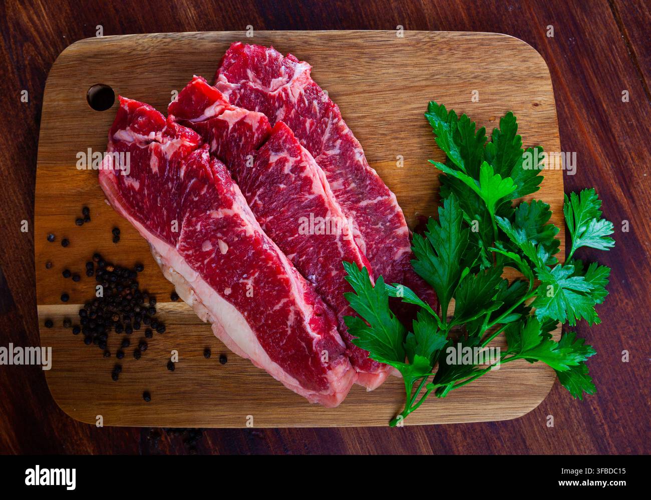 Rohe marmorierte Rindersteaks mit Kräutern und Gewürzen Stockfoto