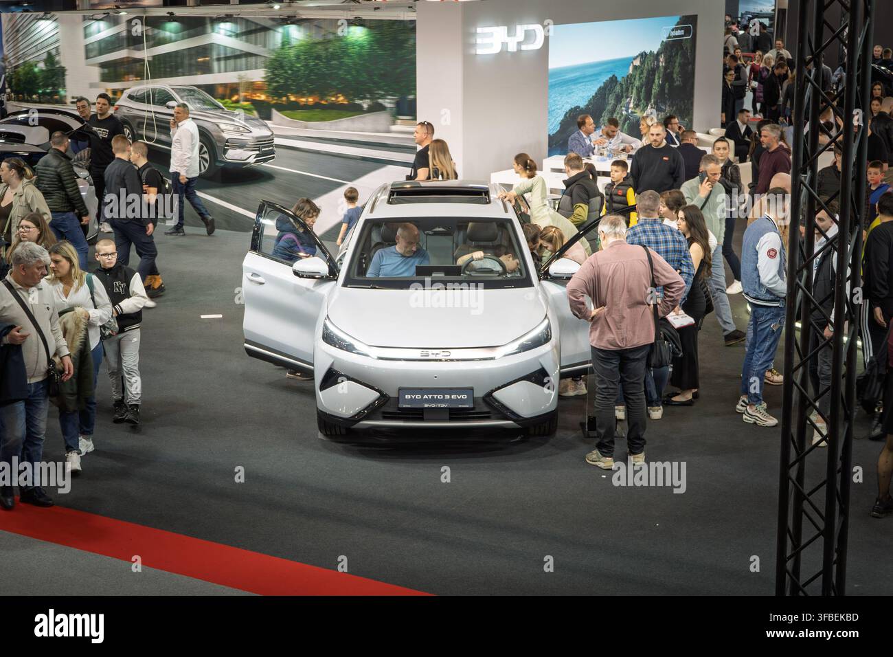 BELGRAD, SERBIEN - 22. MÄRZ 2026: Hochwinkelaufnahme eines weißen BYD ATTO 3 EVO Elektro-SUV, umgeben von Besuchern und potenziellen Käufern, BYD ist ein chines Stockfoto