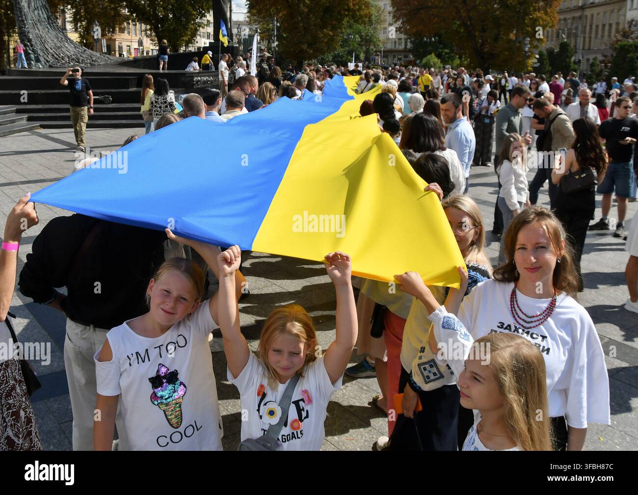 Ukrainer halten eine 35 Meter lange Nationalflagge während einer öffentlichen Veranstaltung zur Feier des Nationalflaggentages in Lemberg, Westukraine, am 23. August 2026. Der Nationalflaggentag wird jährlich in der Ukraine am 23. August begangen, um eines der wichtigsten Staatssymbole des Landes zu ehren. Stockfoto
