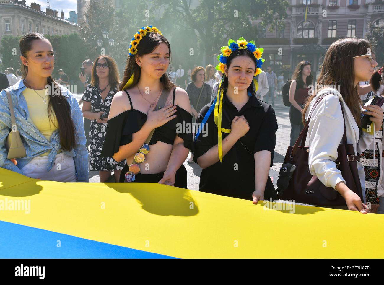 Ukrainer halten eine 35 Meter lange Nationalflagge während einer öffentlichen Veranstaltung zur Feier des Nationalflaggentages in Lemberg, Westukraine, am 23. August 2026. Der Nationalflaggentag wird jährlich in der Ukraine am 23. August begangen, um eines der wichtigsten Staatssymbole des Landes zu ehren. Stockfoto