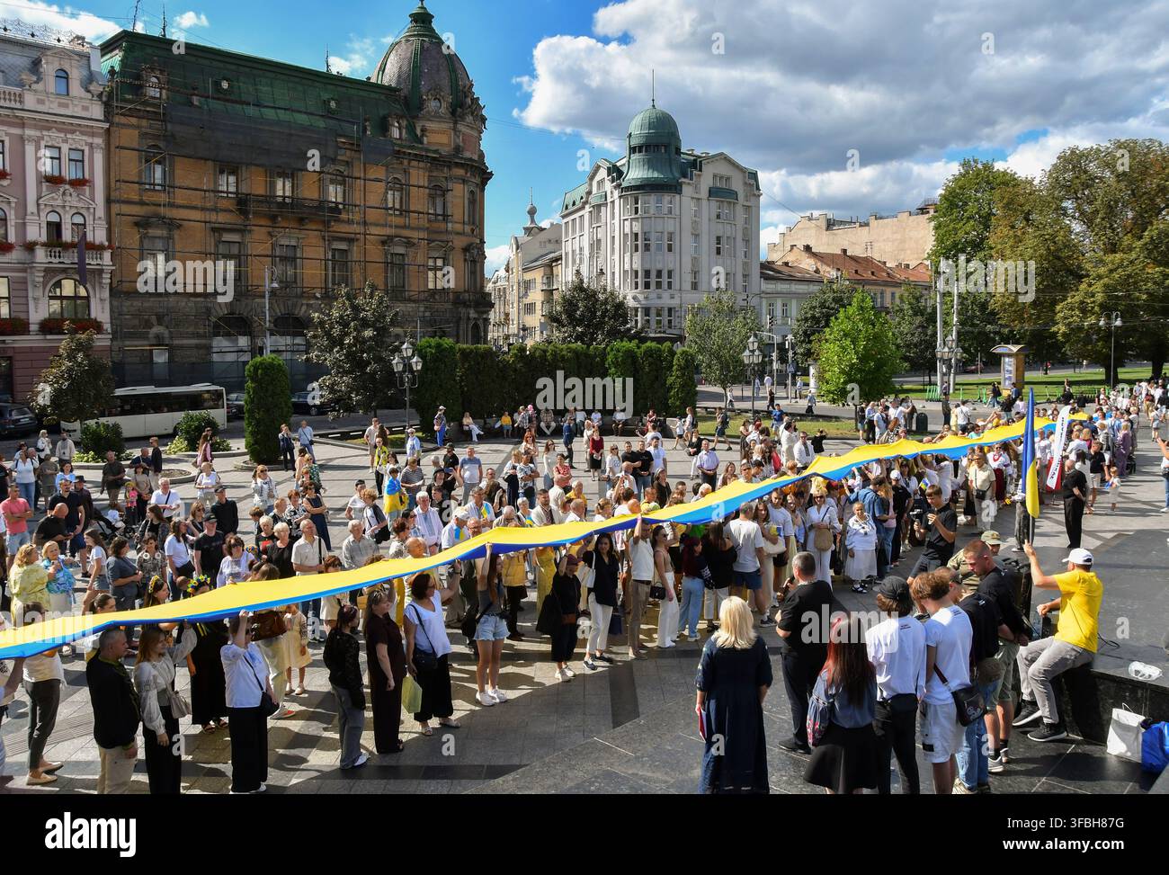 Ukrainer halten eine 35 Meter lange Nationalflagge während einer öffentlichen Veranstaltung zur Feier des Nationalflaggentages in Lemberg, Westukraine, am 23. August 2026. Der Nationalflaggentag wird jährlich in der Ukraine am 23. August begangen, um eines der wichtigsten Staatssymbole des Landes zu ehren. Stockfoto