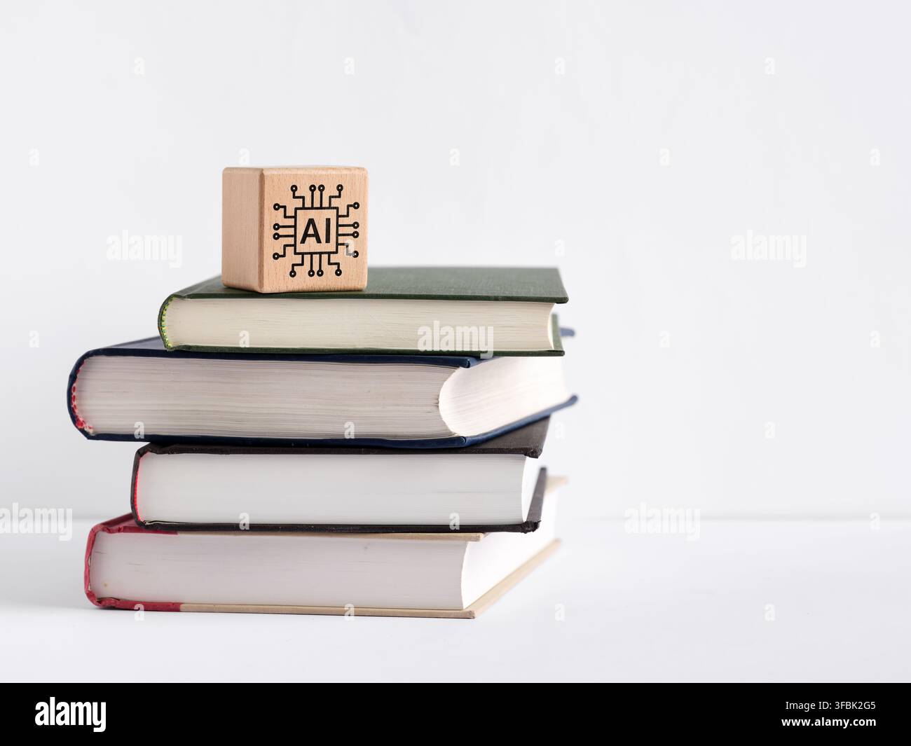 AI-Symbol auf einem Holzblock, der auf einem Stapel Bücher sitzt, repräsentiert künstliche Intelligenz, Lernen, Wissen und Bildung Stockfoto