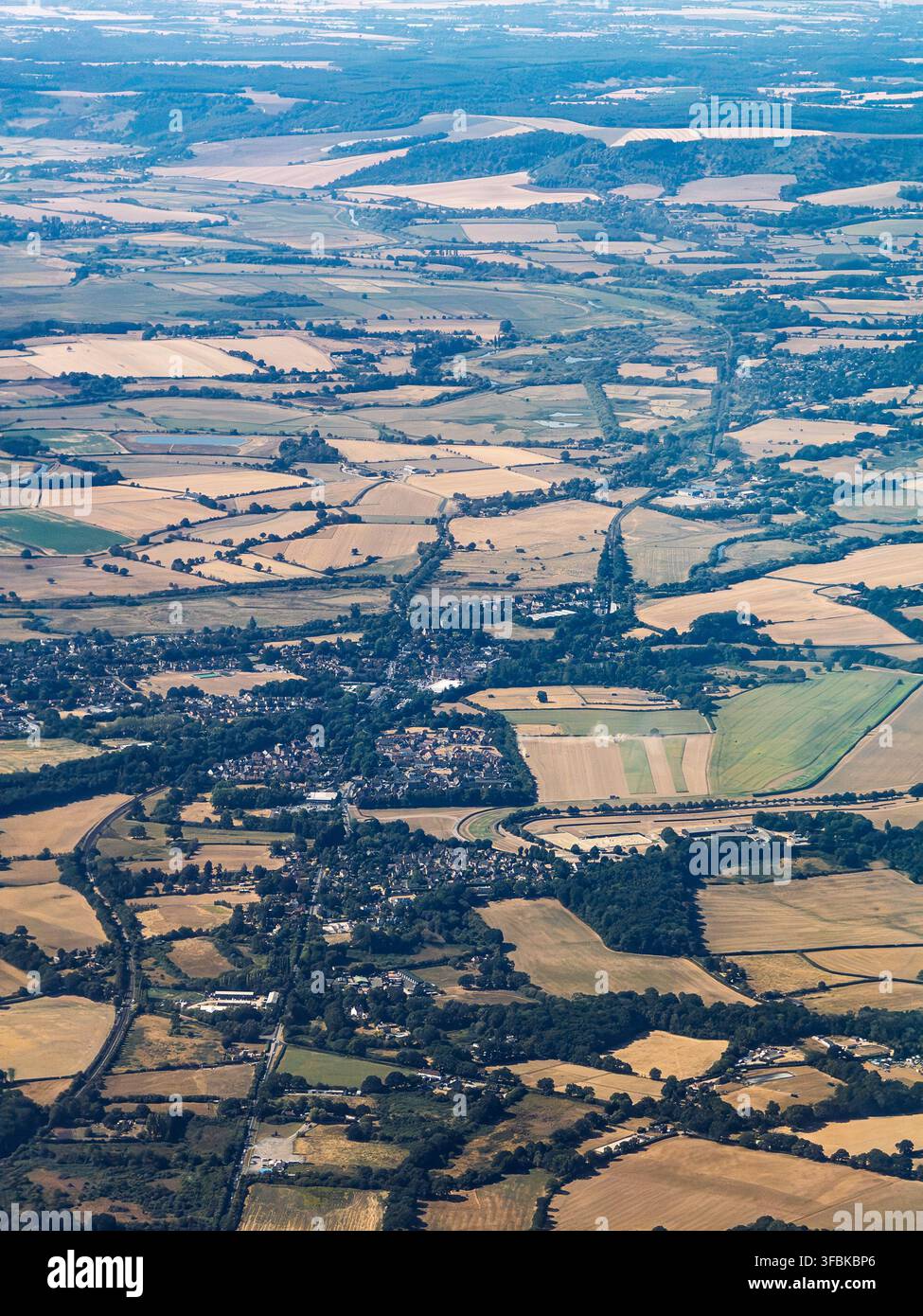 Luftbild aus einem Passagierflugzeug über Pulborough, West Sussex, England, das Dörfer, gewundene Straßen, Wald und ein Flickenteppich aus kultiviertem Land zeigt - Smartphone-aufgenommenes Stockfoto