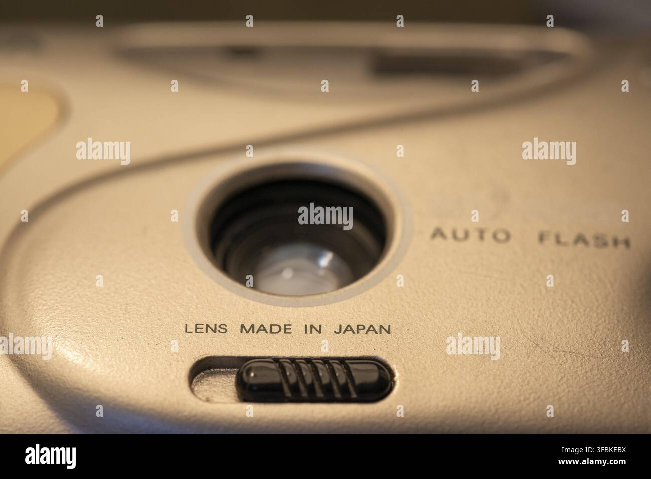 Objektiv hergestellt in Japan, Schrift und Plastikknopf auf billiger Einwegfilmkamera Stockfoto