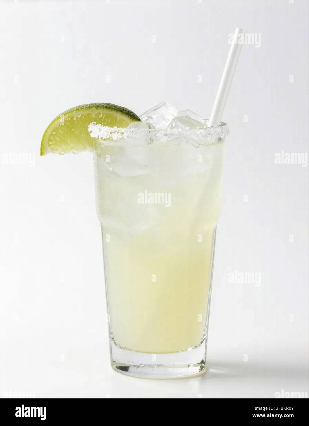 Eine klassische Margarita mit gesalzenem Rand und Limettenspalter, serviert in einem mit Eis gefüllten Glas Stockfoto