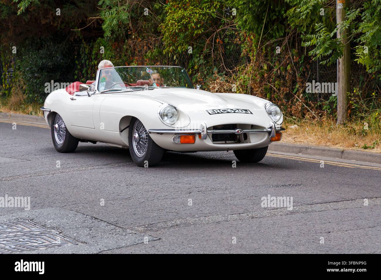 Weißes Cabrio Jaguar E-Type Roadster Klassiker nimmt an der Christchurch Carnival Parade in Christchurch, Bournemouth, Dorset, UK im August teil Stockfoto