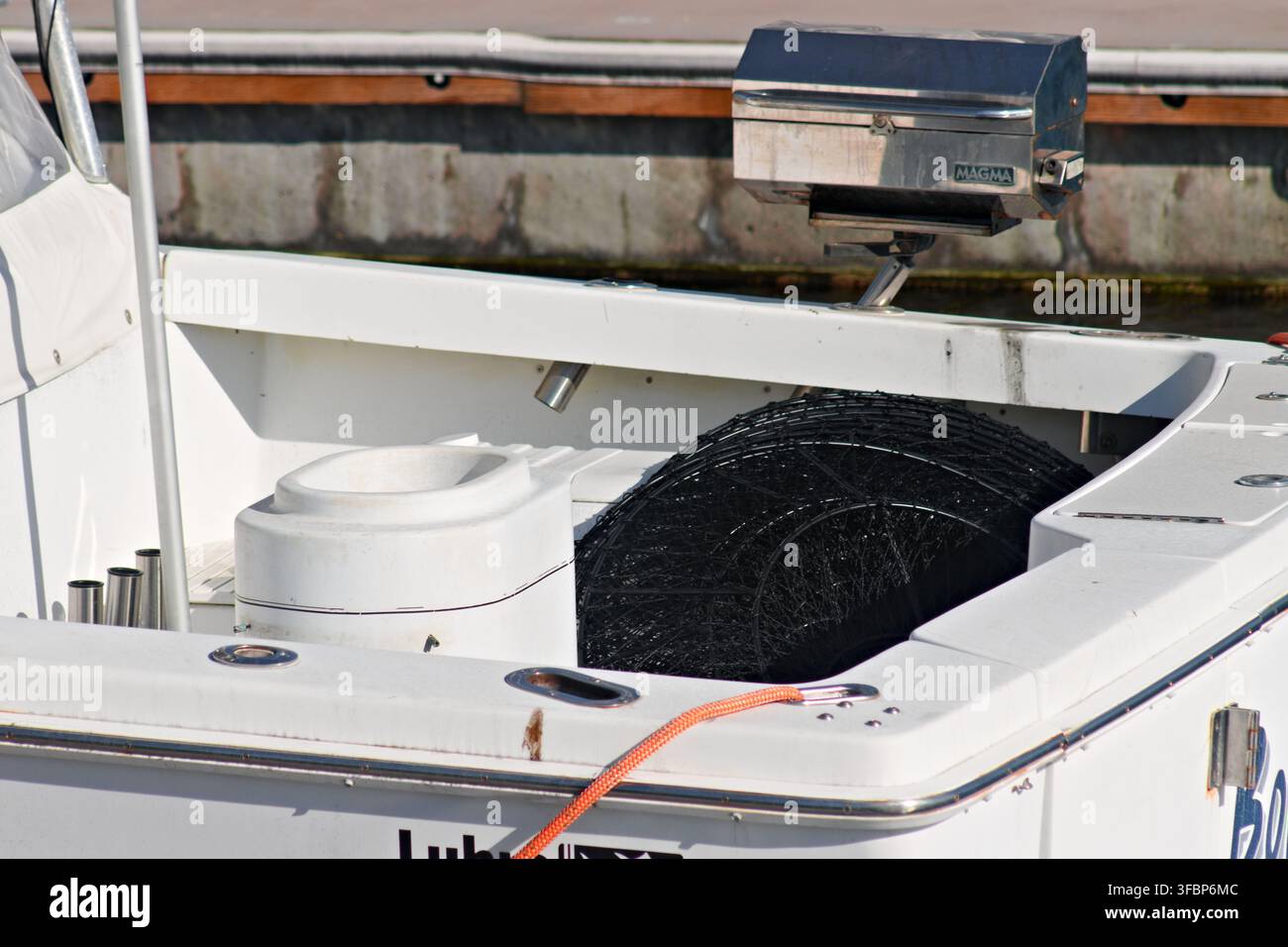 Bootsrumpf mit montiertem Grill, Fischernetz, orangefarbenem Seil und Hafenausrüstung an einem Yachthafen in Long Beach. Stockfoto