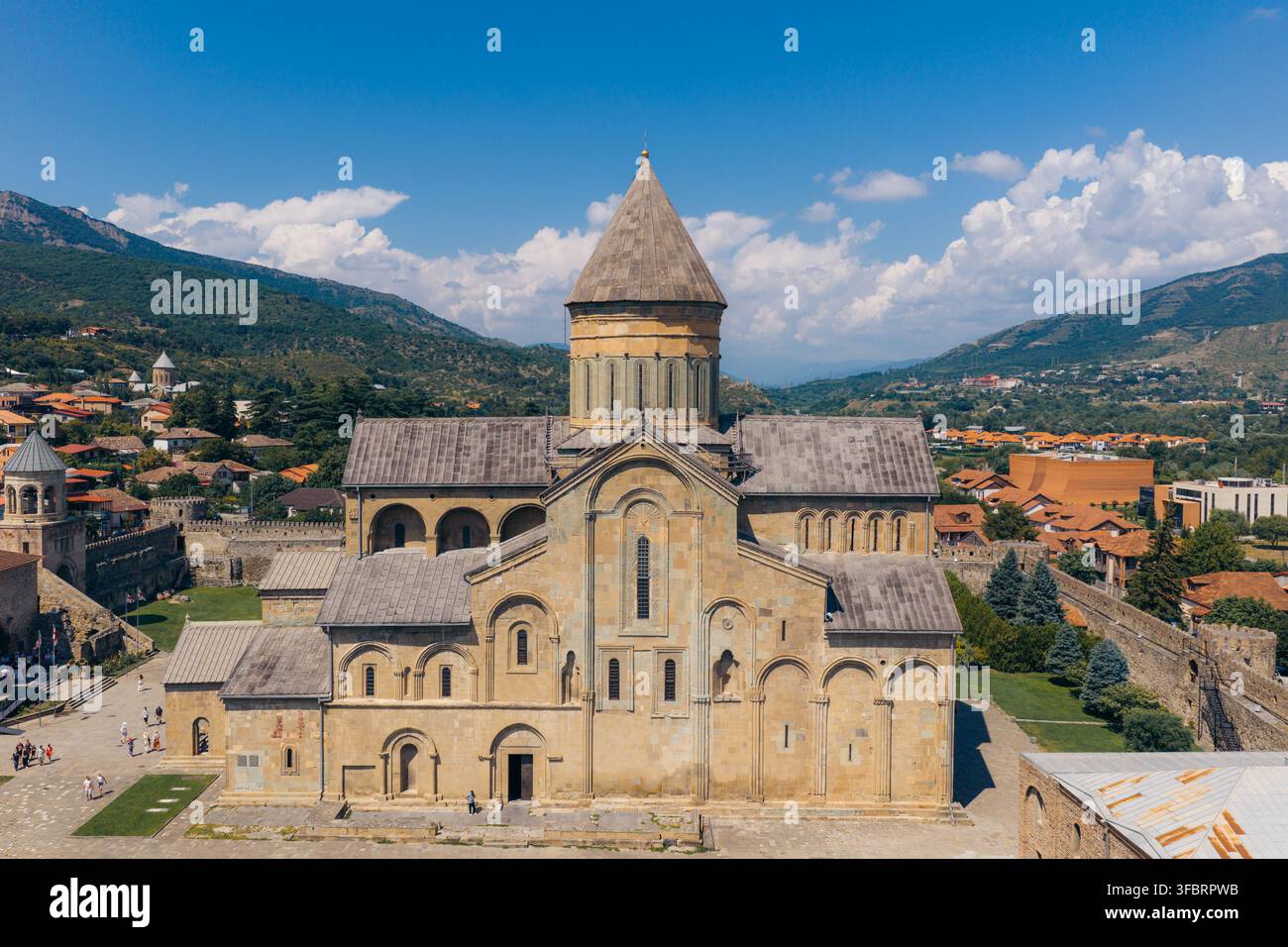 Luftbild der historischen Svetitskhoveli-Kathedrale mit ihren Steinmauern und kegelförmigen Kuppel, umgeben von der Stadt Mtskheta, Mtskheta-Mtianeti, Geo Stockfoto
