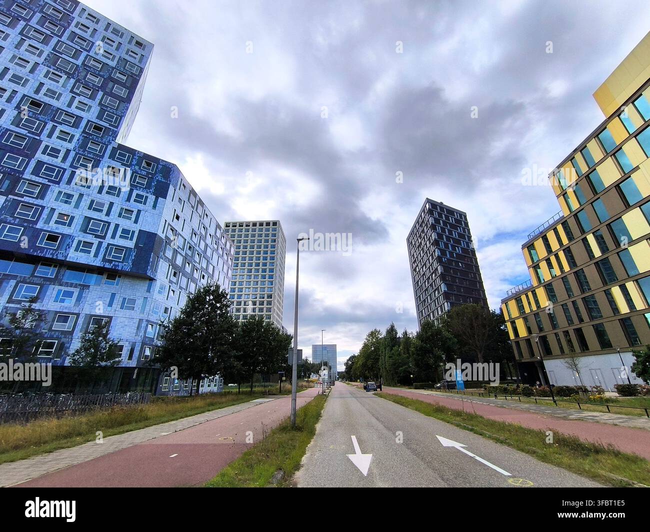 Moderne urbane Ansicht von zeitgenössischen Apartmenttürmen, einer Straße und einer bewölkten Himmelstadtlandschaft im Utrecht Science Park, Universität von Utrecht, Niederlande Stockfoto