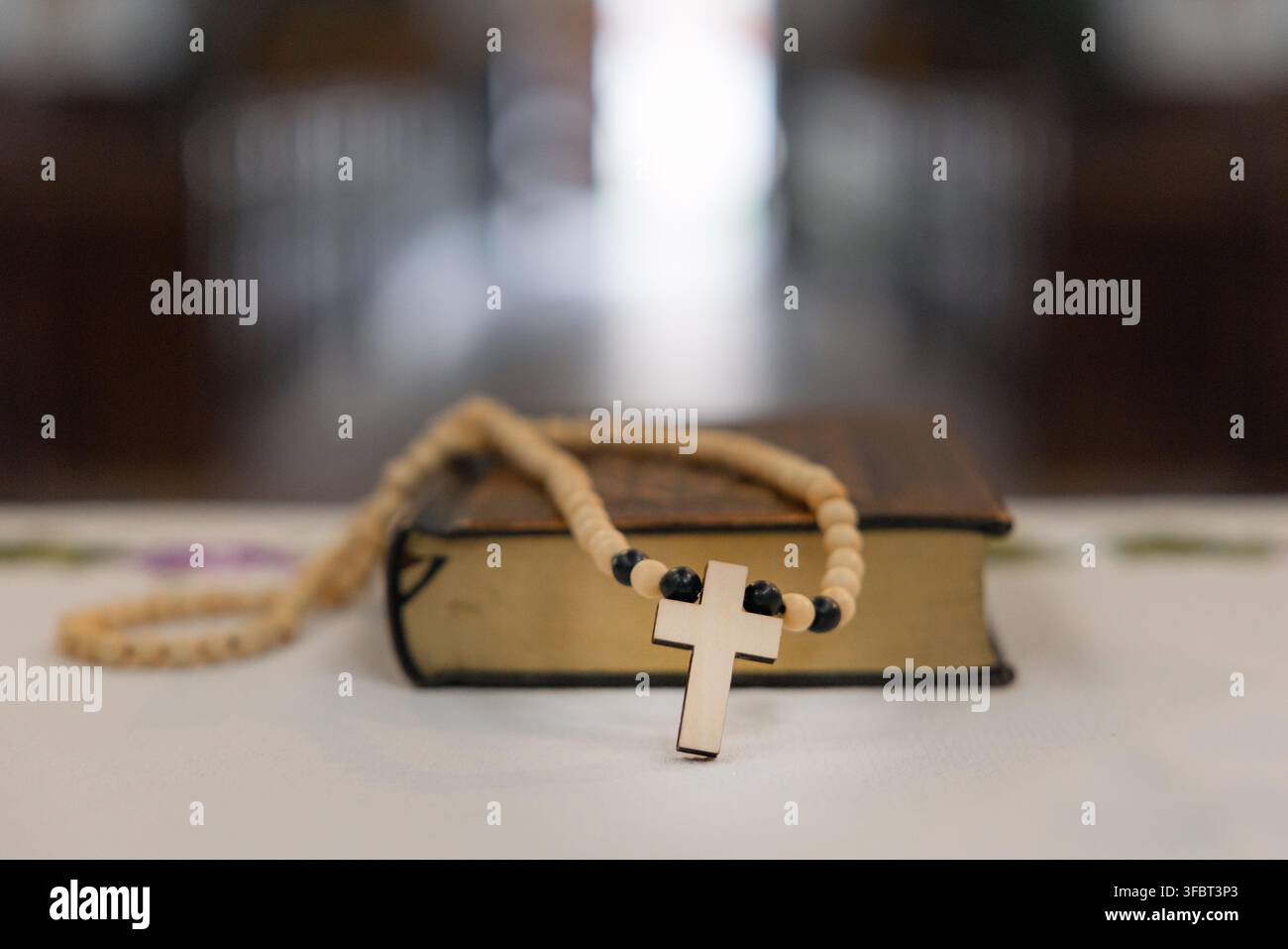 Heilige Messe am Altar in einer katholischen Kirche. Details der Heiligen Bibel und des Rosenkranzes auf dem Altar. Stockfoto