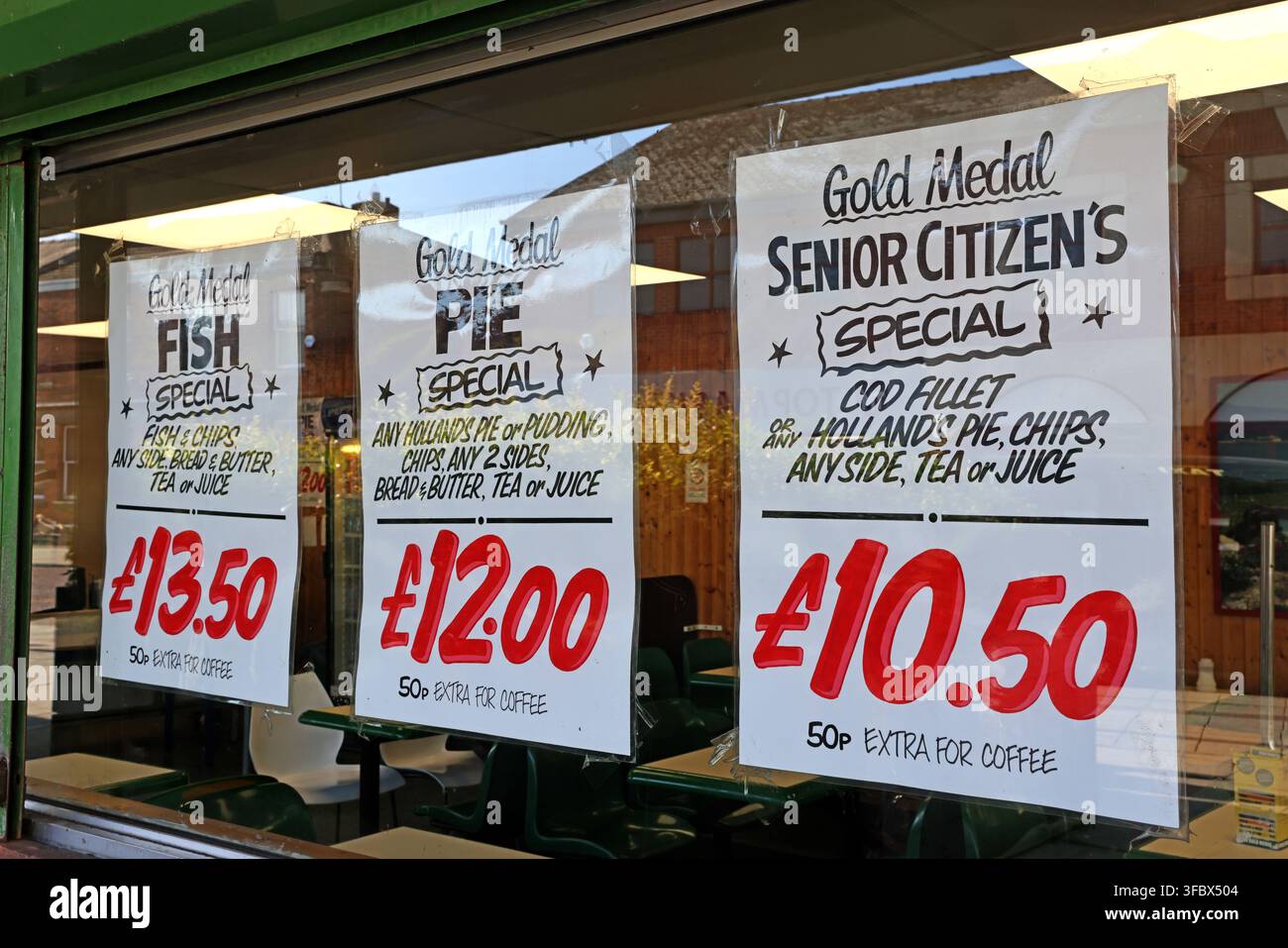 Billige Mahlzeitangebote, die in einem Restaurantfenster in Ashton-under-Lyne, Greater Manchester, England, beworben werden. Stockfoto