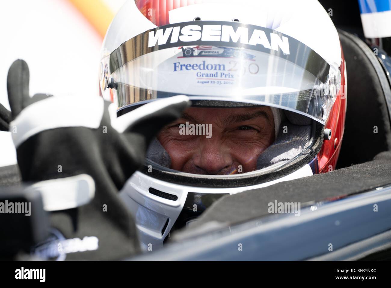 Washington, Vereinigte Staaten. 23. August 2026. NASA-Astronaut Reid Wiseman, Kommandant von Artemis II, trägt einen Rennhelm und sitzt in einem Zweisitzer-IndyCar, während er sich darauf vorbereitet, dass Fahrer Conor Daly ihn während einer Übungseinheit vor dem Freedom 250 Grand Prix am 22. August 2026 in Washington, D.C., eine Runde auf der Strecke fährt. Credit: Joel Kowsky/NASA Photo/Alamy Live News Stockfoto