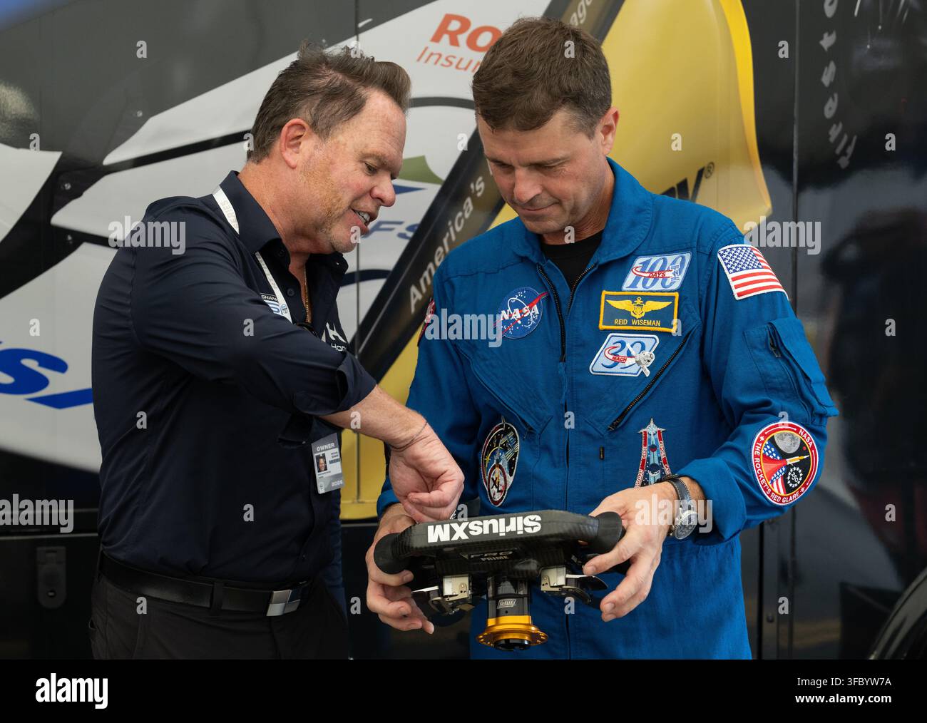 Washington, Vereinigte Staaten. 22. August 2026. NASA-Astronaut Reid Wiseman, Kommandant von Artemis II, rechts, betrachtet ein NTT IndyCar-Lenkrad mit Mike Shank, Besitzer von Meyer Shank Racing, während einer Übungssitzung vor dem Freedom 250 Grand Prix am 22. August 2026 in Washington, D.C.Credit: Joel Kowsky/NASA Photo/Alamy Live News Stockfoto