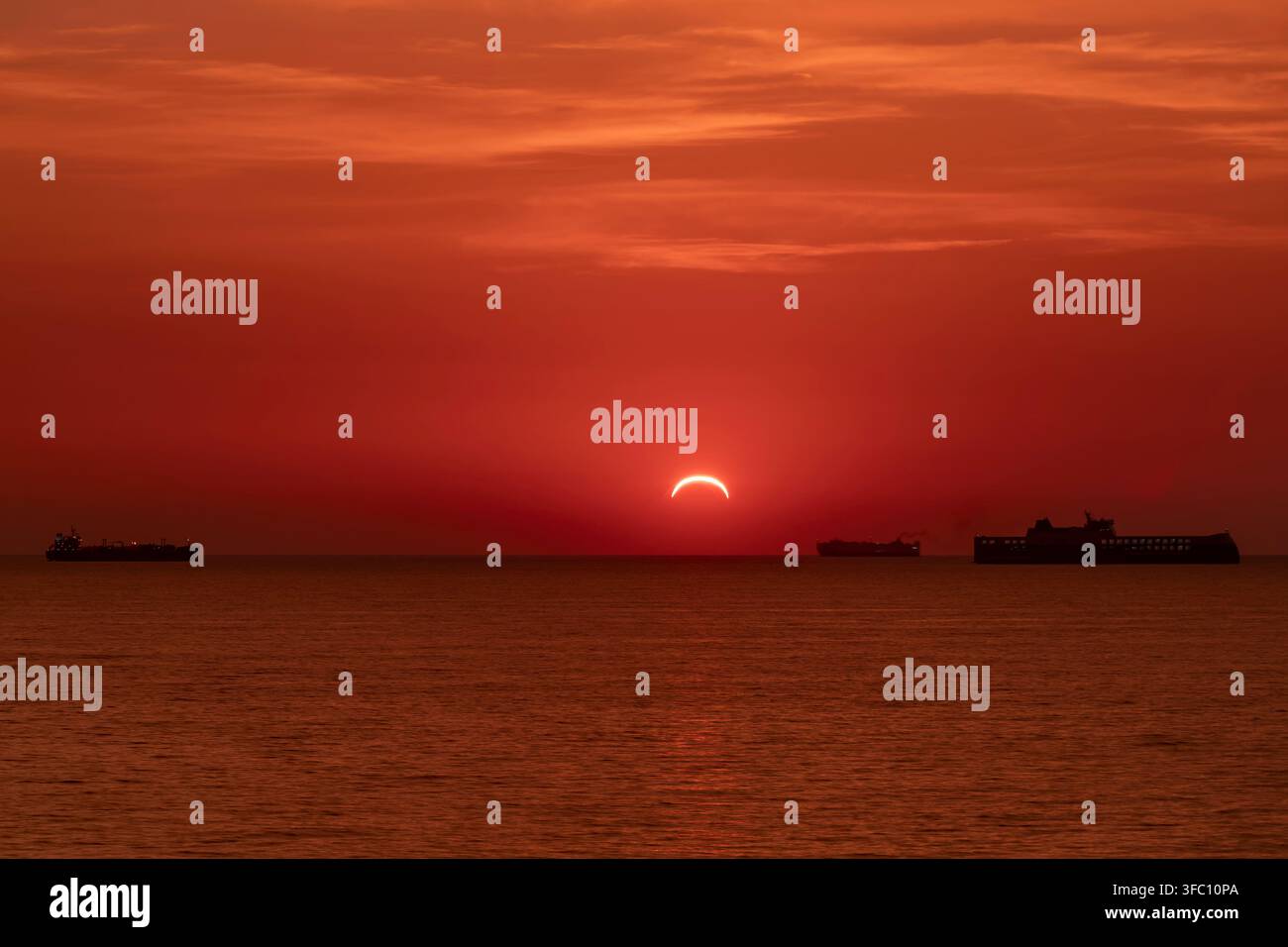 Schiffverkehr am Horizont während des Sonnenuntergangs am 12. August 2026 mit der Sonnenfinsternis auf ihrem Maximum, Livorno, Italien Stockfoto