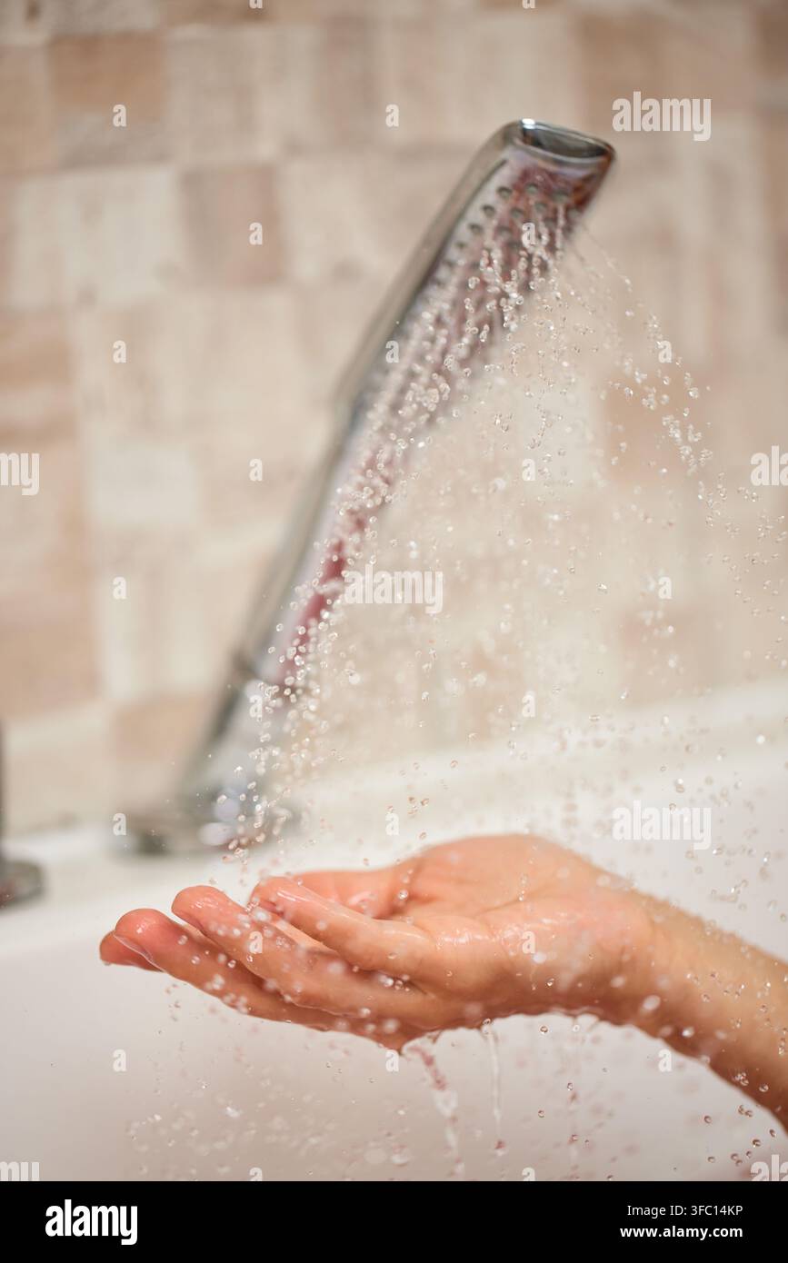 Hand fängt frisches Wasser aus der Dusche Stockfoto