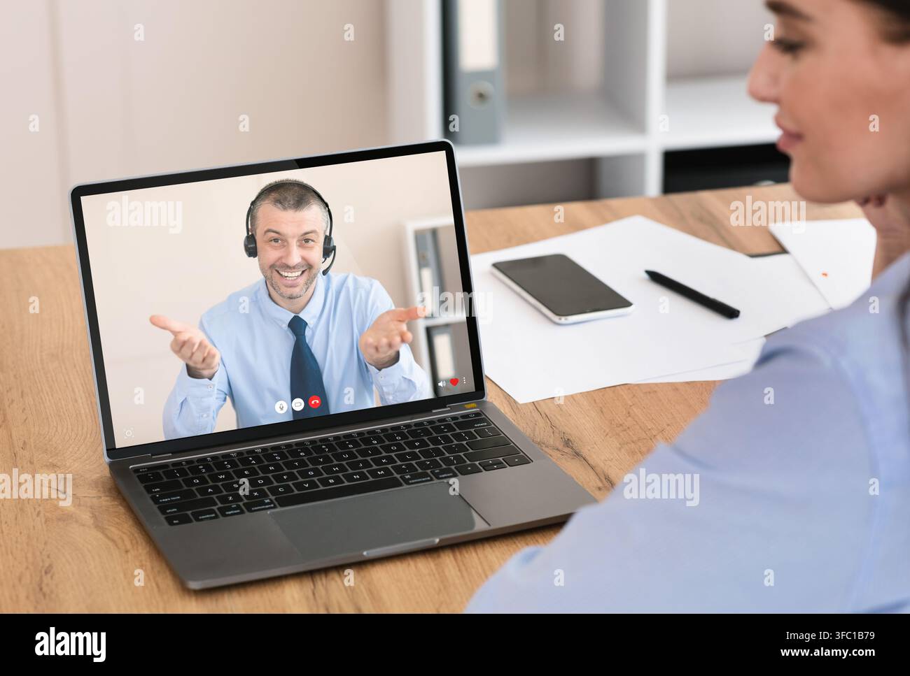 Junge Frau mit Gespräch mit Service-Center-Vertreter online Stockfoto