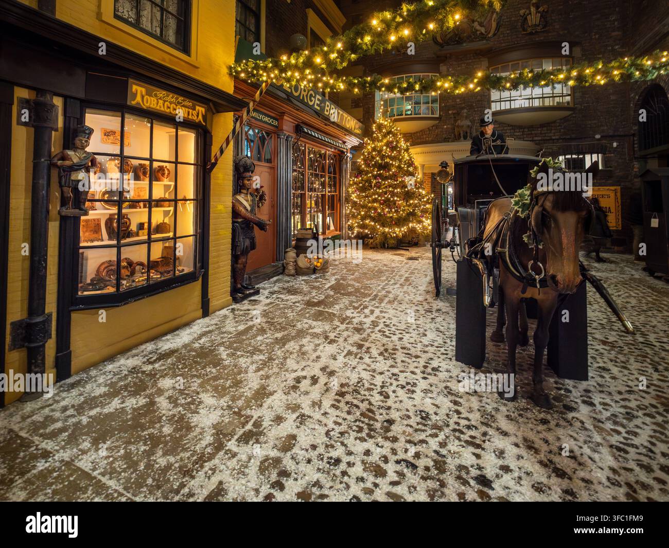 Schnee-Effekt-Viktorianische Straßenszene mit Kutsche, Weihnachtsbaum und Schaufenstern an der Kirkgate im York Castle Museum. Stockfoto
