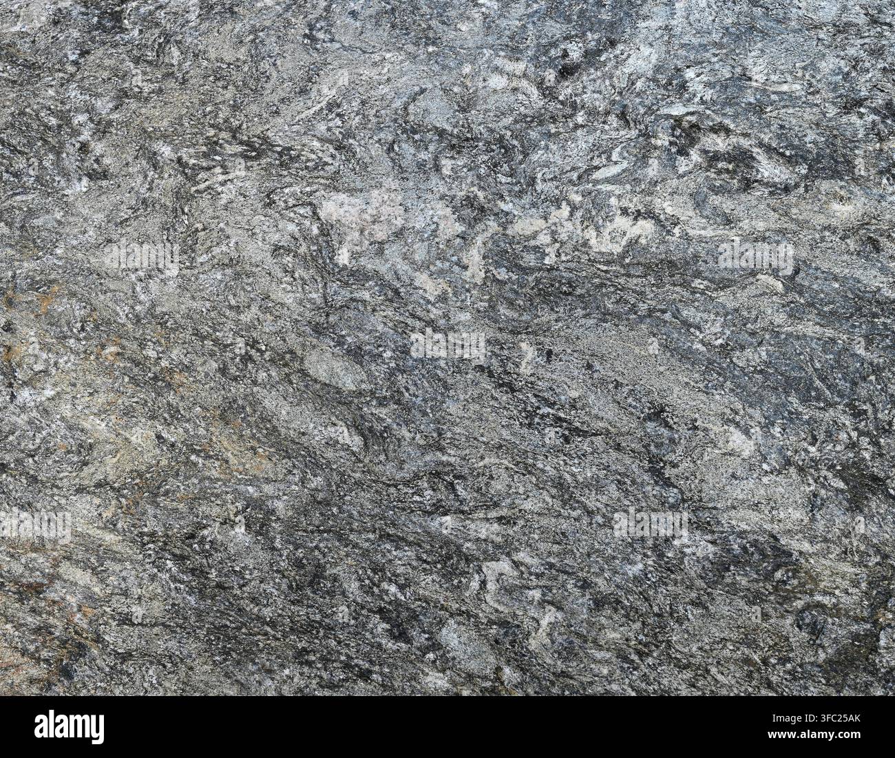 Horizontale abstrakte unebene Felsfläche mit porösen Erhöhungen, Vertiefungen, Mineralbändern, schwarzen Sprenkeln und blauen sowie braunen Farbtönen über grauem Stein Stockfoto