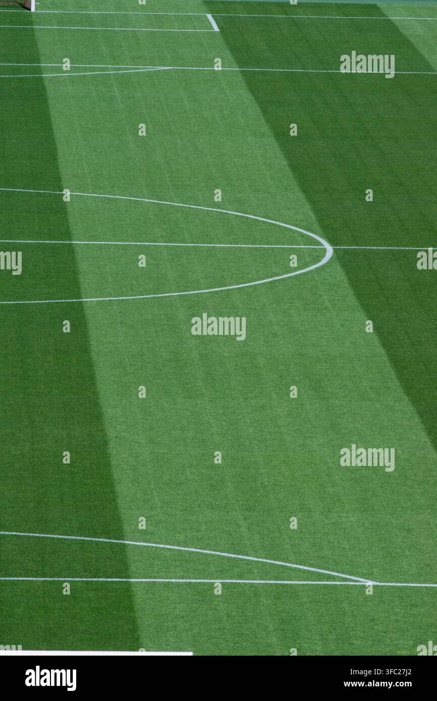 Vertikale Porträtansicht des Mittelfeldkreises und der geraden Spiellinie auf gestreiftem grünem Fußballrasen. Stockfoto