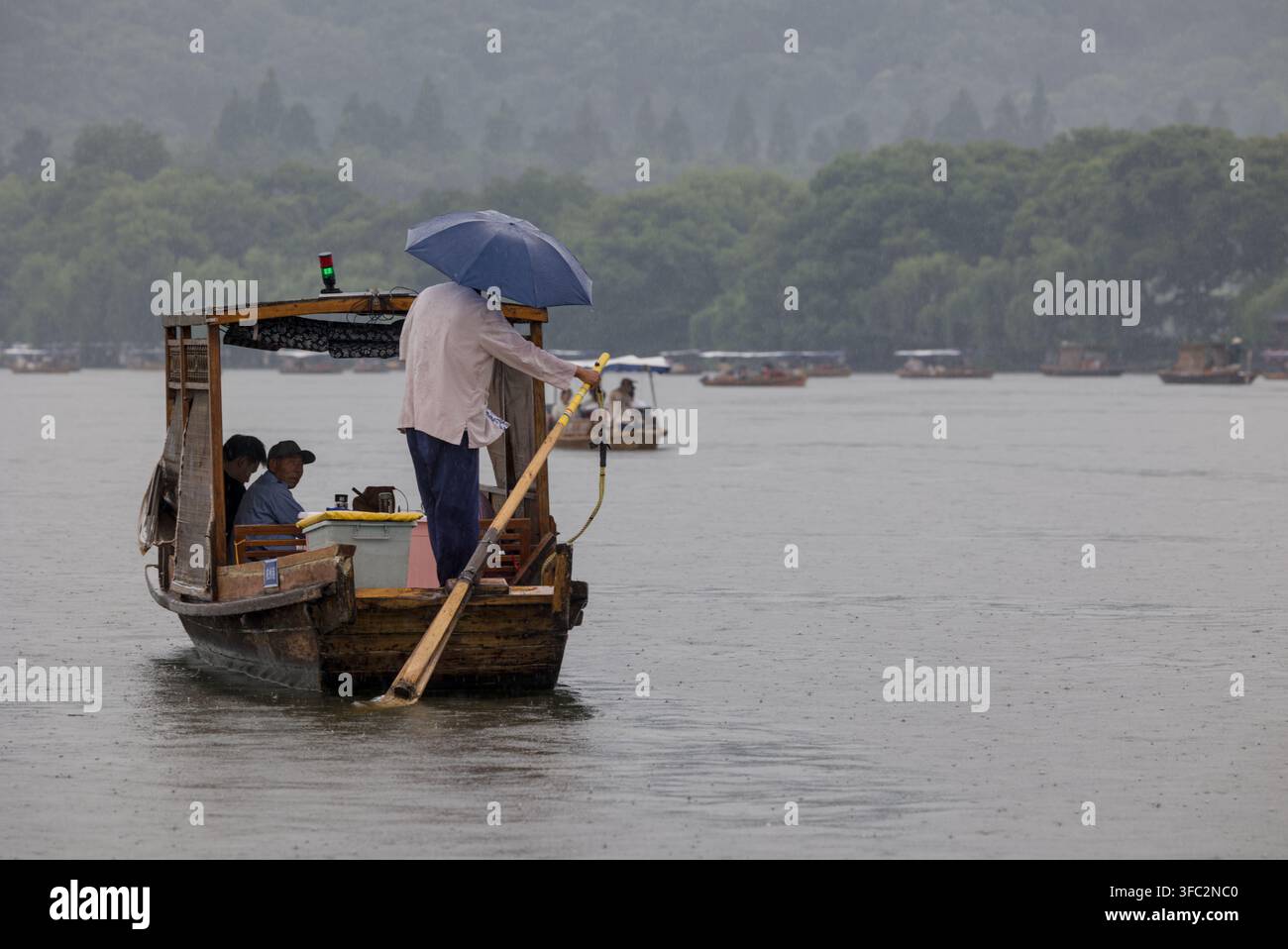 Traditionelles Touristenboot am Westsee in Hangzhou, China, an einem regnerischen Tag Stockfoto