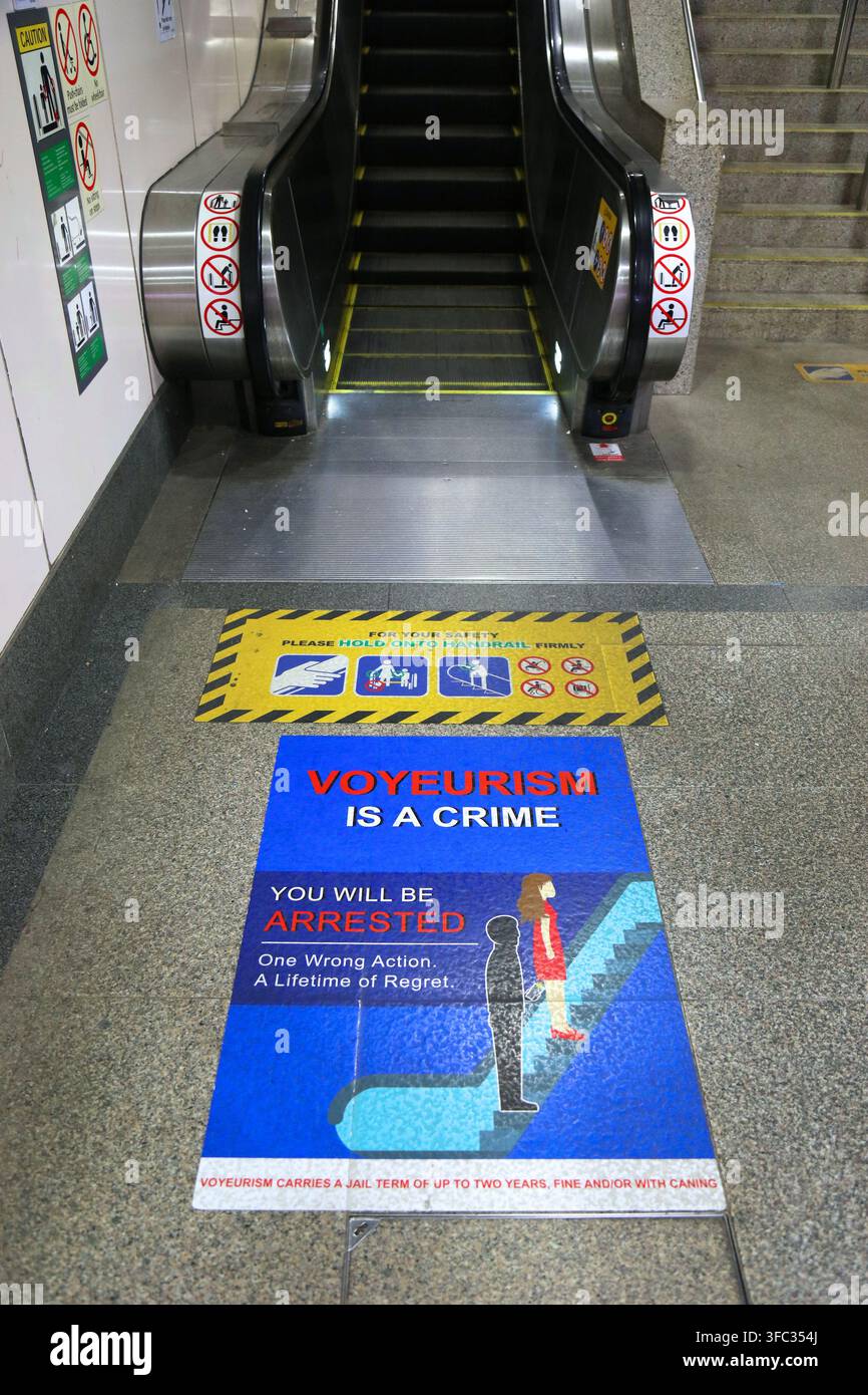 SINGAPUR STADT, SINGAPUR - 12. MÄRZ 2024: Öffentlicher Verkehr Singapur MRT-Station mit Voyeurismus-Kriminalitätswarnung. Stockfoto