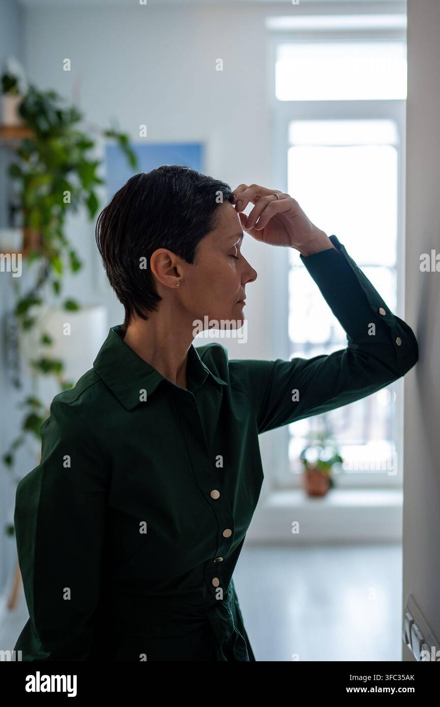 Depressive, hoffnungslose Frau, die allein an der Wand steht und nicht in emotionaler Not weiterleben kann Stockfoto
