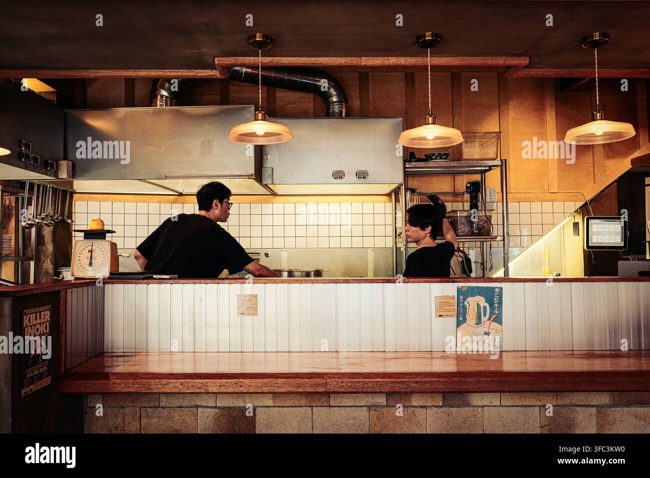 Zwei Männer arbeiten in einer geschäftigen offenen Küche eines Ramen-Restaurants in Gwangbok-dong, Busan, Südkorea. Stockfoto