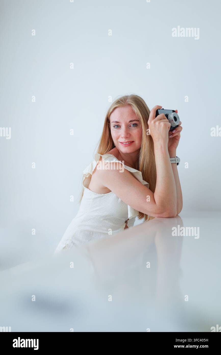 Glückliche Fotografin posiert mit einer Kamera im Retro-Stil, kreativer Beruf, Reise- und Fotokonzept. Stockfoto