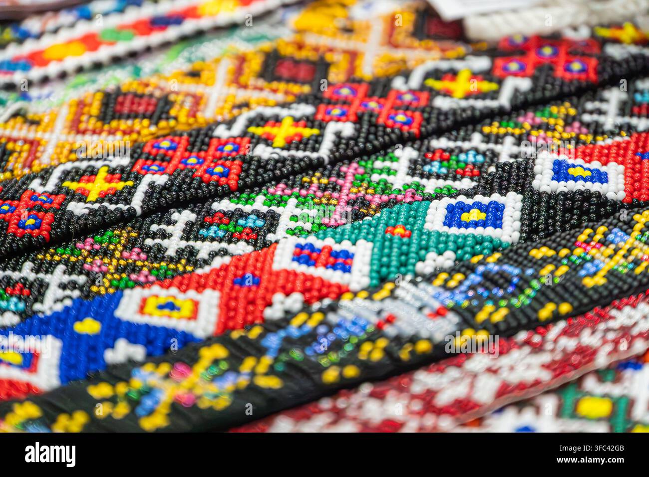 Lebendiges Perlenmuster in hellen Primär- und Sekundärfarben, das kunstvolle handwerkliche Design, detaillierte Handwerkskunst und farbenfrohe repetitive Sy Stockfoto