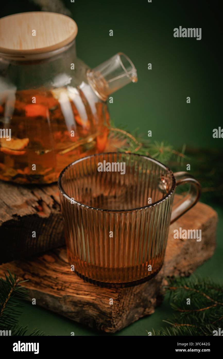 Vertikale Komposition mit Kräutertee, Glasbecher und rustikaler Holzdeko mit Kopierraum für Weihnachtsgrußkarten und saisonale Wellness-Designs Stockfoto