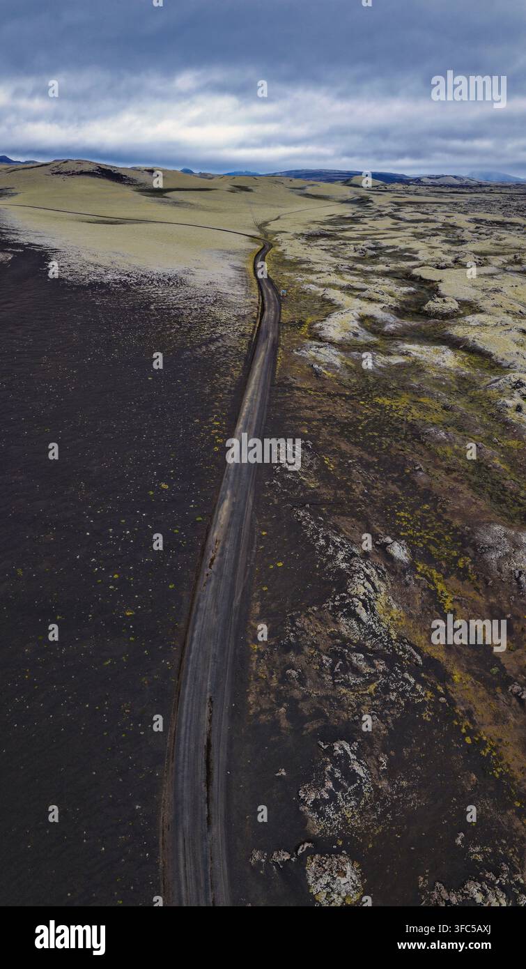 Drohnenperspektive der Route 1, die schwarzes vulkanisches Gelände und braune Sandebenen in Südisland durchquert. Stockfoto