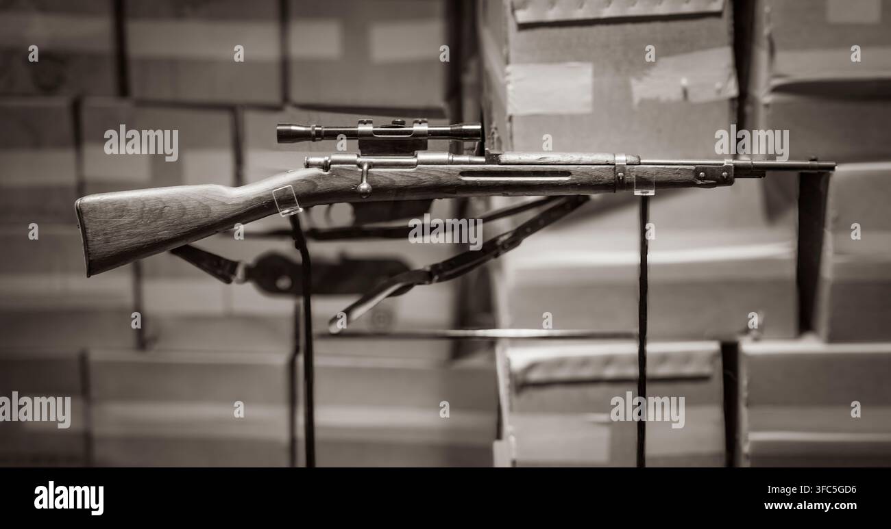 Eine Duplikatkopie des 6,5 x 52 mm italienischen Carcano M91/38 Repetiergewehrs mit Bolzenverschluss, ausgestattet mit einem 4x Hollywood-Marken-Zielfernrohr, das von Lee Harvey Oswald, dem mutmaßlichen Mörder von Präsident John F. Kennedy am 22. November 1963 in Dallas, Texas, verwendet wurde. Dieses Gewehr wird im Lagerraum im sechsten Stock des Texas School Book Depository ausgestellt, wo Oswald einen Aussichtspunkt über dem Dealey Plaza fand, entlang dessen Kennedy, der texanische Gouverneur John Connally und ihre Ehefrauen in einer Autokolonne fuhren. Heute Sixth Floor Museum genannt, wird der Ort von der Dallas County Historical Foundation betrieben. Das Originalgewehr und ein Stockfoto